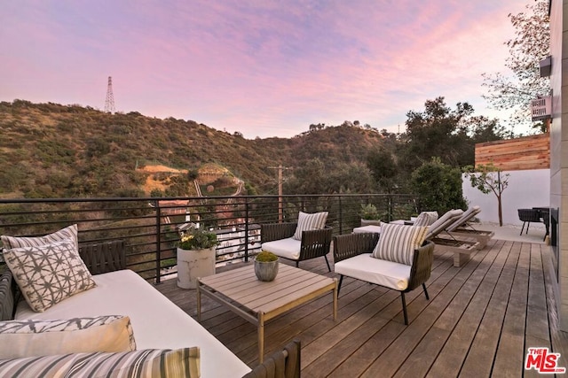 deck at dusk with a mountain view and an outdoor hangout area