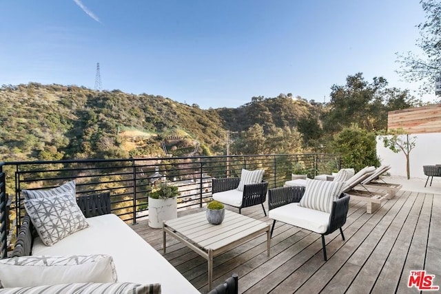 wooden deck featuring an outdoor living space and a mountain view