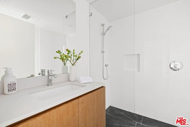 bathroom featuring vanity and tiled shower