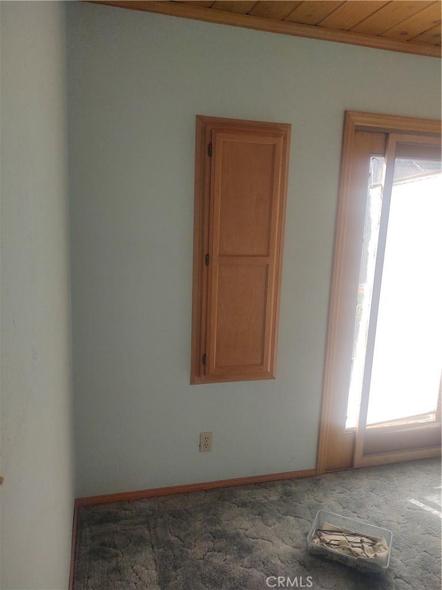 carpeted empty room with ornamental molding and wood ceiling