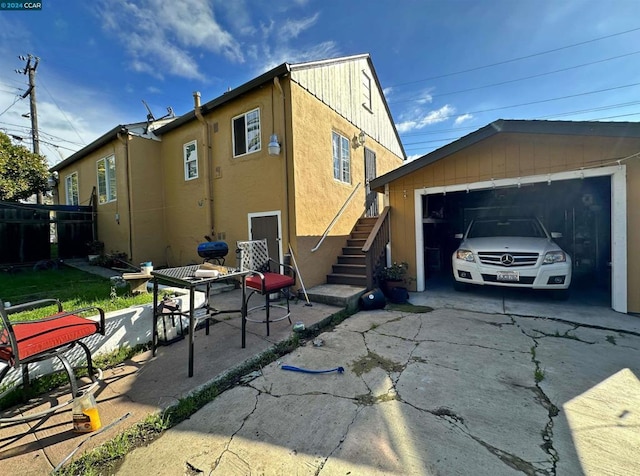 view of side of property featuring a garage and a patio