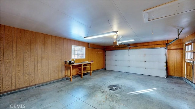 garage with a garage door opener and wood walls