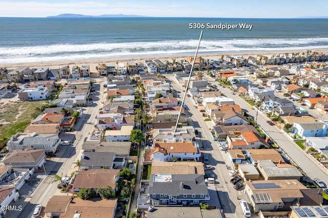 birds eye view of property with a water view and a beach view