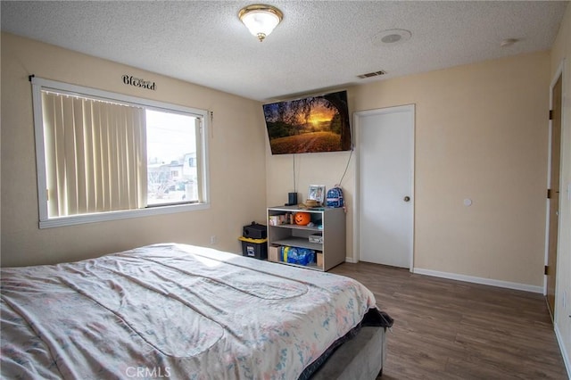 bedroom with hardwood / wood-style floors and a textured ceiling