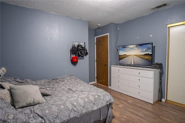 bedroom featuring hardwood / wood-style flooring and a textured ceiling