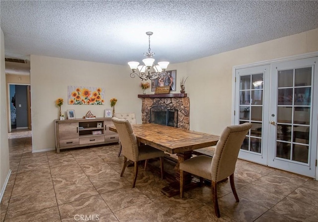 dining area with an inviting chandelier, a stone fireplace, french doors, and a textured ceiling