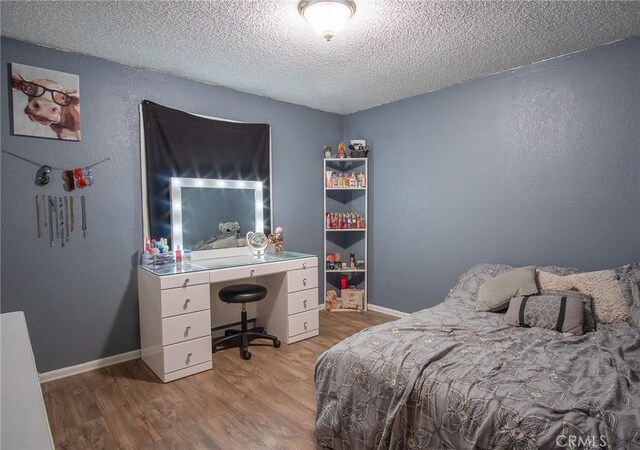 bedroom with a textured ceiling and light hardwood / wood-style floors