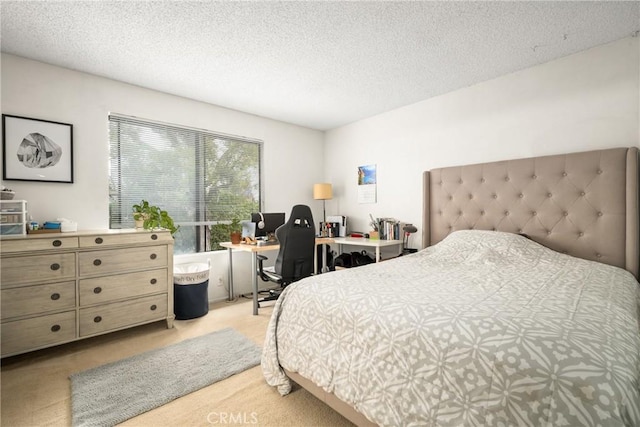 bedroom featuring light colored carpet and a textured ceiling