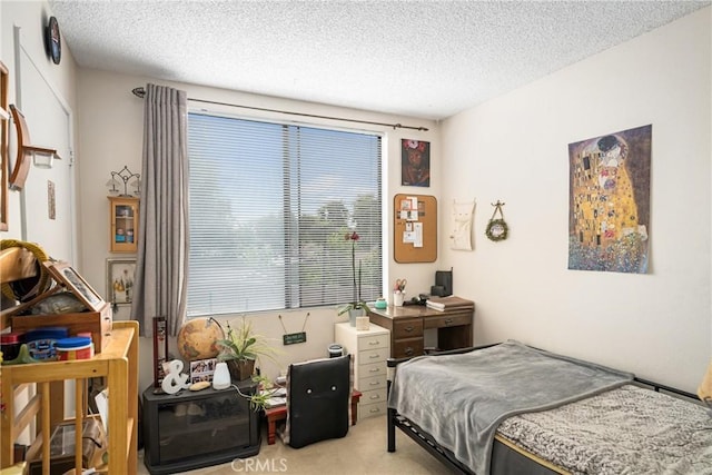 bedroom featuring a textured ceiling and light carpet