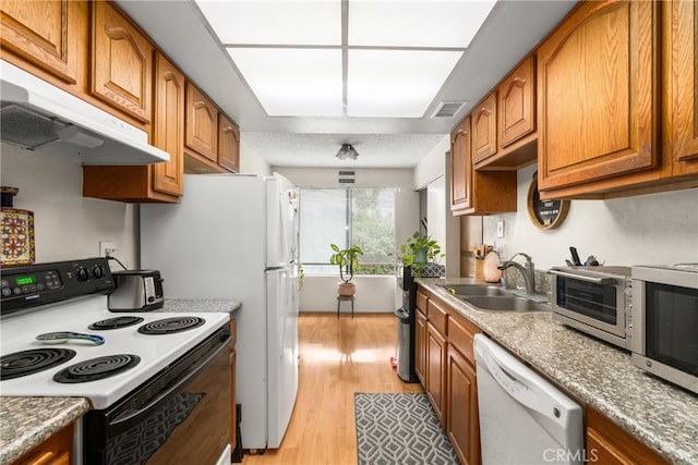 kitchen with sink, white appliances, and light wood-type flooring