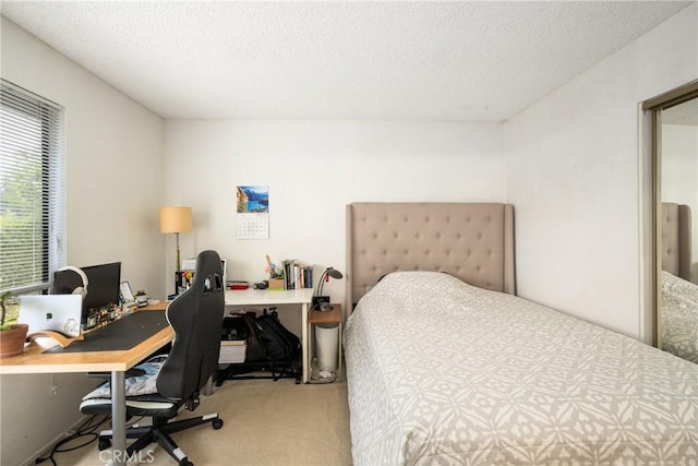 bedroom with light colored carpet and a textured ceiling