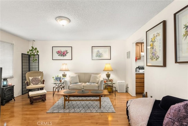 living room featuring light hardwood / wood-style flooring and a textured ceiling