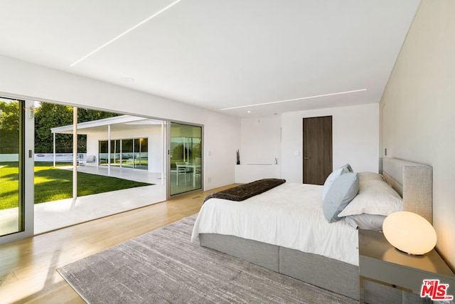 bedroom featuring light wood-type flooring and access to exterior