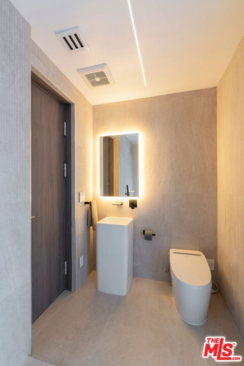 bathroom featuring toilet and concrete flooring