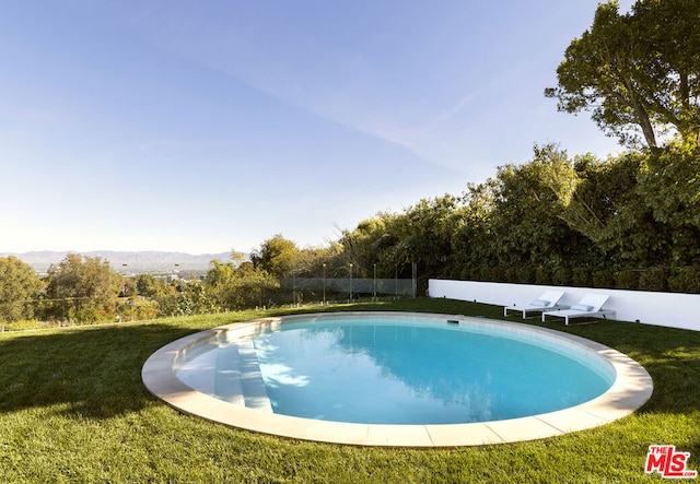 view of pool featuring a yard and a mountain view