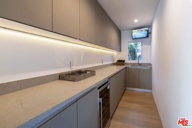 kitchen with light hardwood / wood-style floors, wine cooler, sink, and gray cabinets