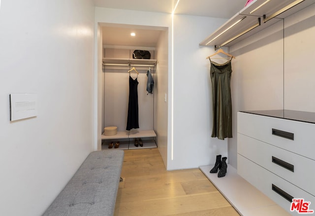 walk in closet with light hardwood / wood-style flooring