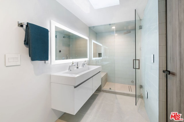 bathroom featuring vanity, a shower with shower door, and tile patterned flooring