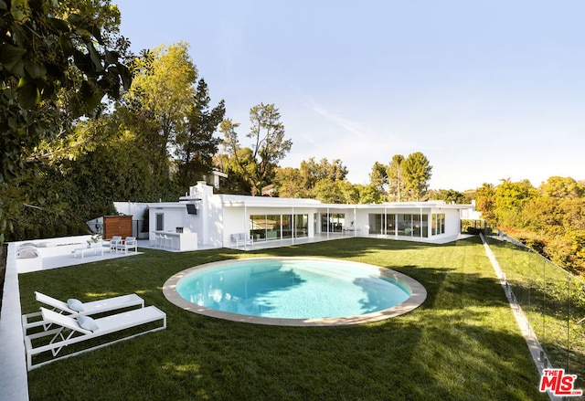 rear view of property featuring a patio and a lawn