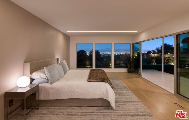 bedroom with light hardwood / wood-style floors and access to outside