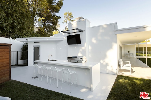 view of patio featuring an outdoor kitchen, an outdoor wet bar, and a grill