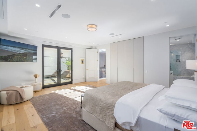 bedroom featuring connected bathroom, french doors, access to exterior, and light wood-type flooring