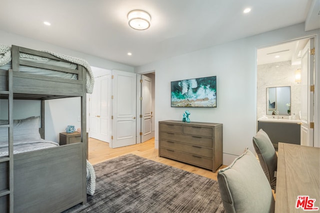 bedroom featuring ensuite bathroom and light hardwood / wood-style floors