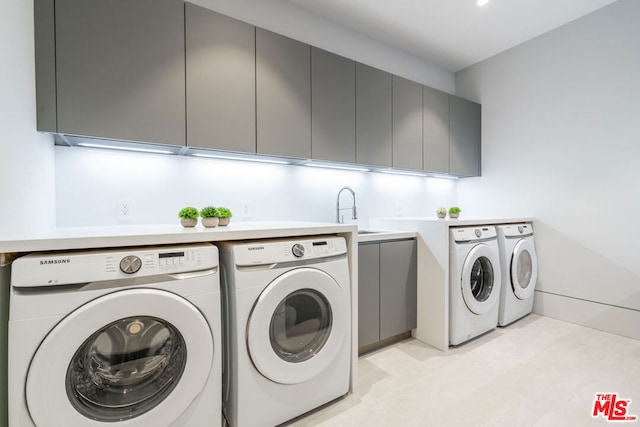 laundry area with sink, cabinets, and washer and clothes dryer