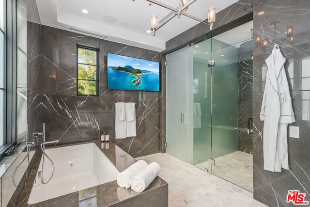 bathroom featuring tile walls and separate shower and tub