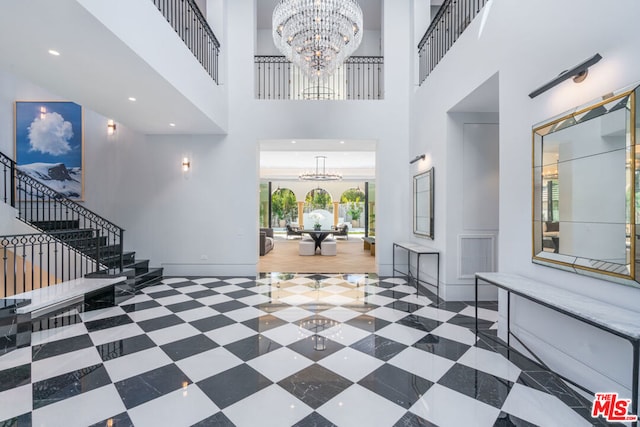 entryway with a towering ceiling and a chandelier