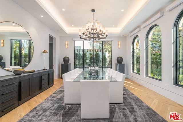 dining room with a chandelier, a tray ceiling, and plenty of natural light