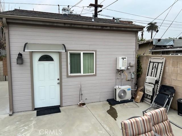 back of property with ac unit and a patio