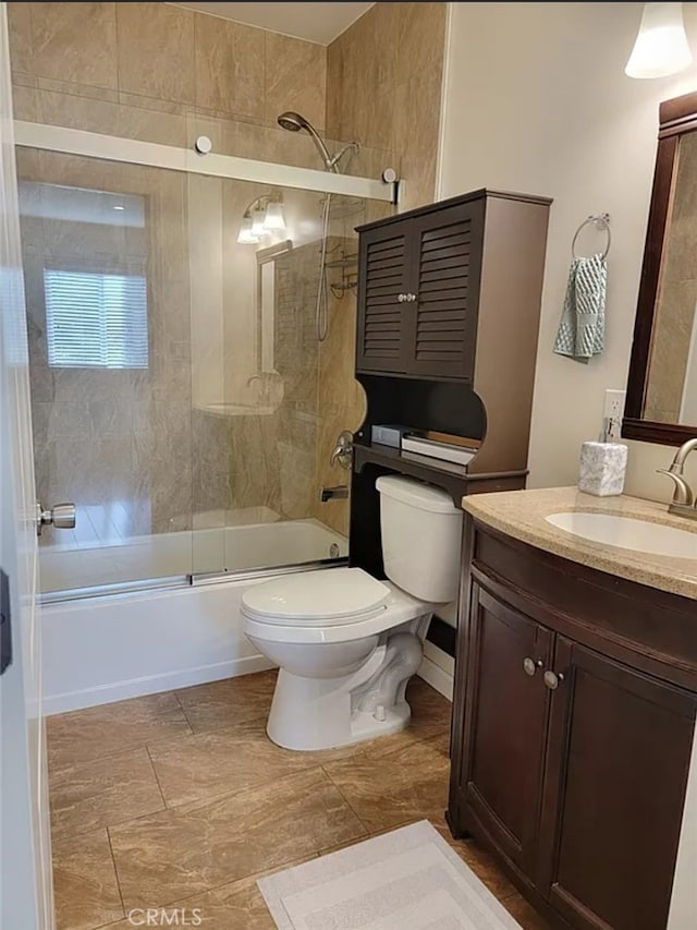 full bathroom featuring vanity, toilet, and bath / shower combo with glass door