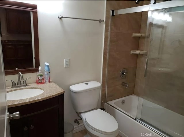 full bathroom featuring toilet, combined bath / shower with glass door, and vanity