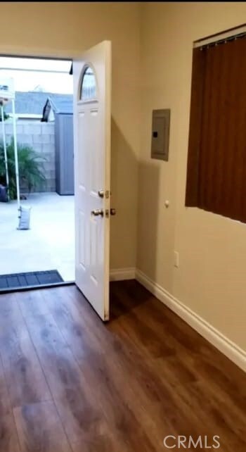 doorway to outside with electric panel and dark wood-type flooring