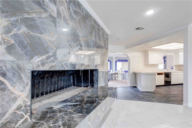 living room with tile walls, ornamental molding, and a large fireplace