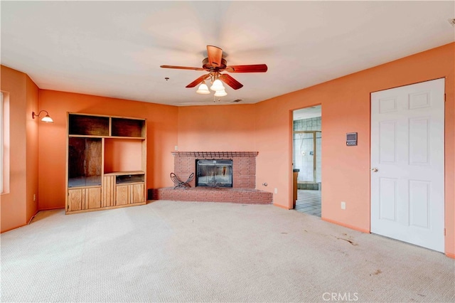 unfurnished living room featuring carpet, a fireplace, and ceiling fan