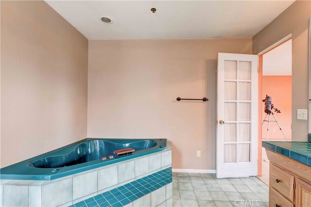 bathroom with vanity and a relaxing tiled tub