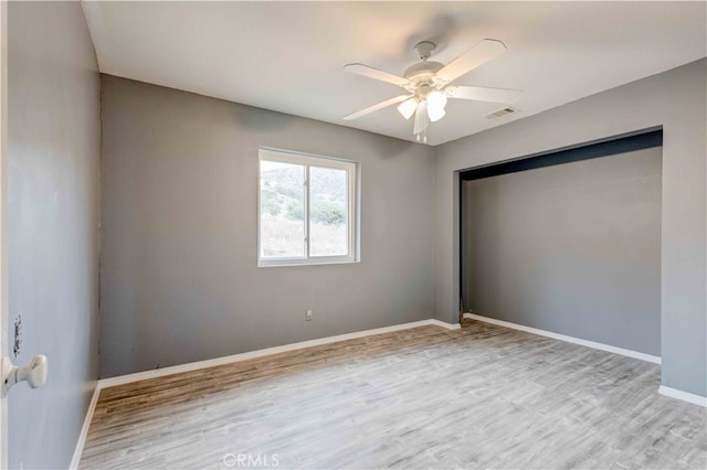 empty room with ceiling fan and light hardwood / wood-style floors