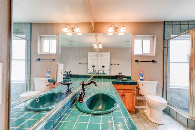 bathroom with tile patterned flooring, walk in shower, vanity, and toilet