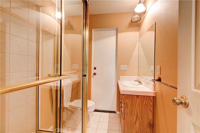 bathroom featuring walk in shower, vanity, tile patterned flooring, and toilet