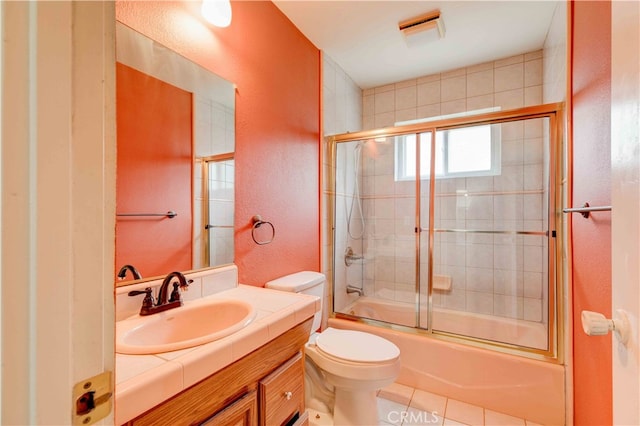 full bathroom featuring vanity, tile patterned floors, toilet, and combined bath / shower with glass door