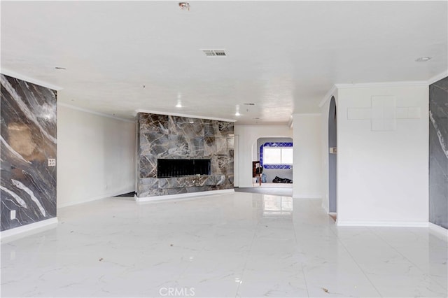 unfurnished living room featuring a stone fireplace and crown molding