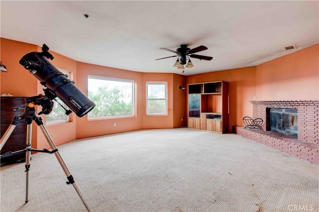 workout area with ceiling fan, a fireplace, and carpet flooring