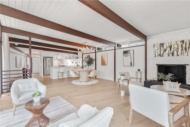 living room with wooden ceiling, a chandelier, light hardwood / wood-style floors, and beamed ceiling