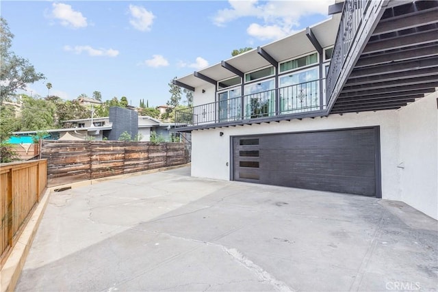 view of patio featuring a balcony and a garage