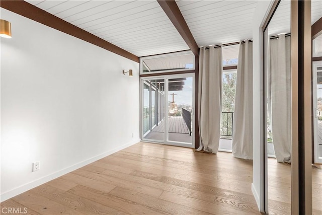 interior space featuring a wall of windows, hardwood / wood-style floors, and beam ceiling