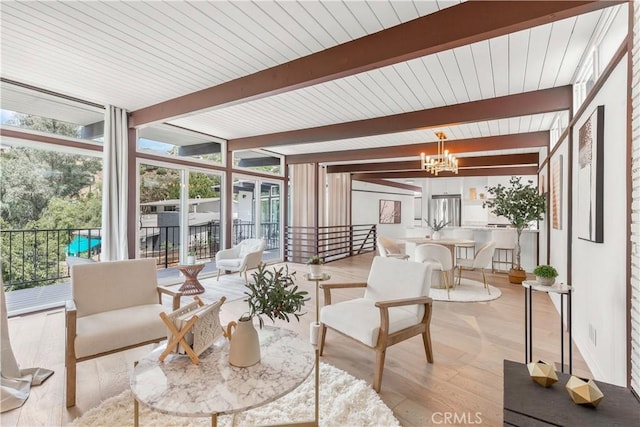 sunroom featuring an inviting chandelier and beamed ceiling