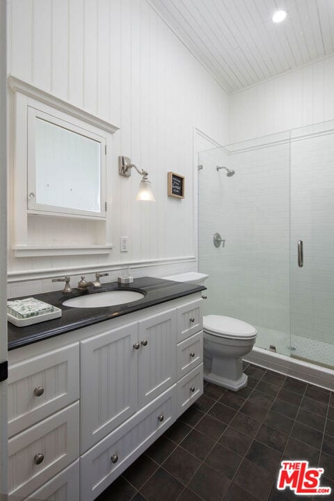 bathroom featuring vanity, toilet, and walk in shower