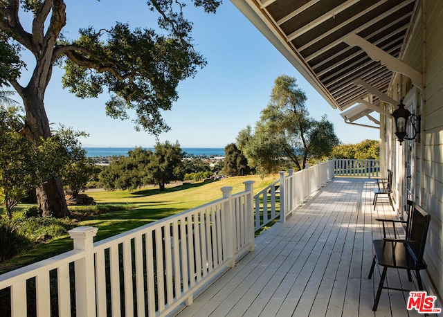 wooden deck featuring a yard and a water view